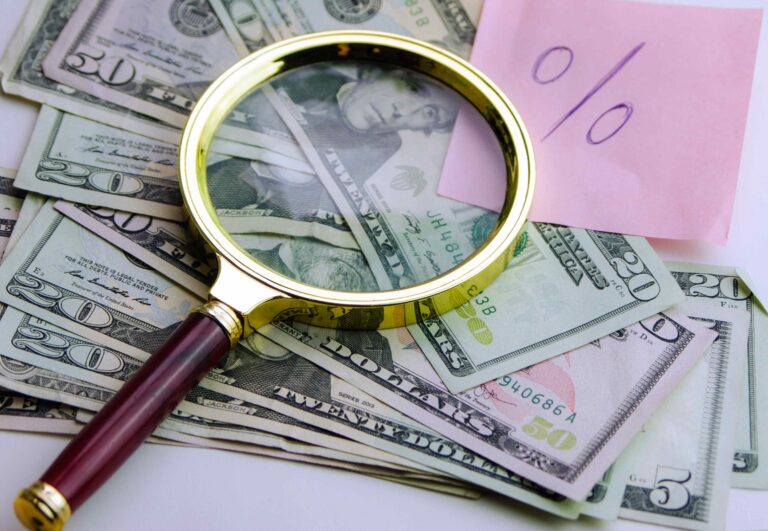 Money and magnifying glass.